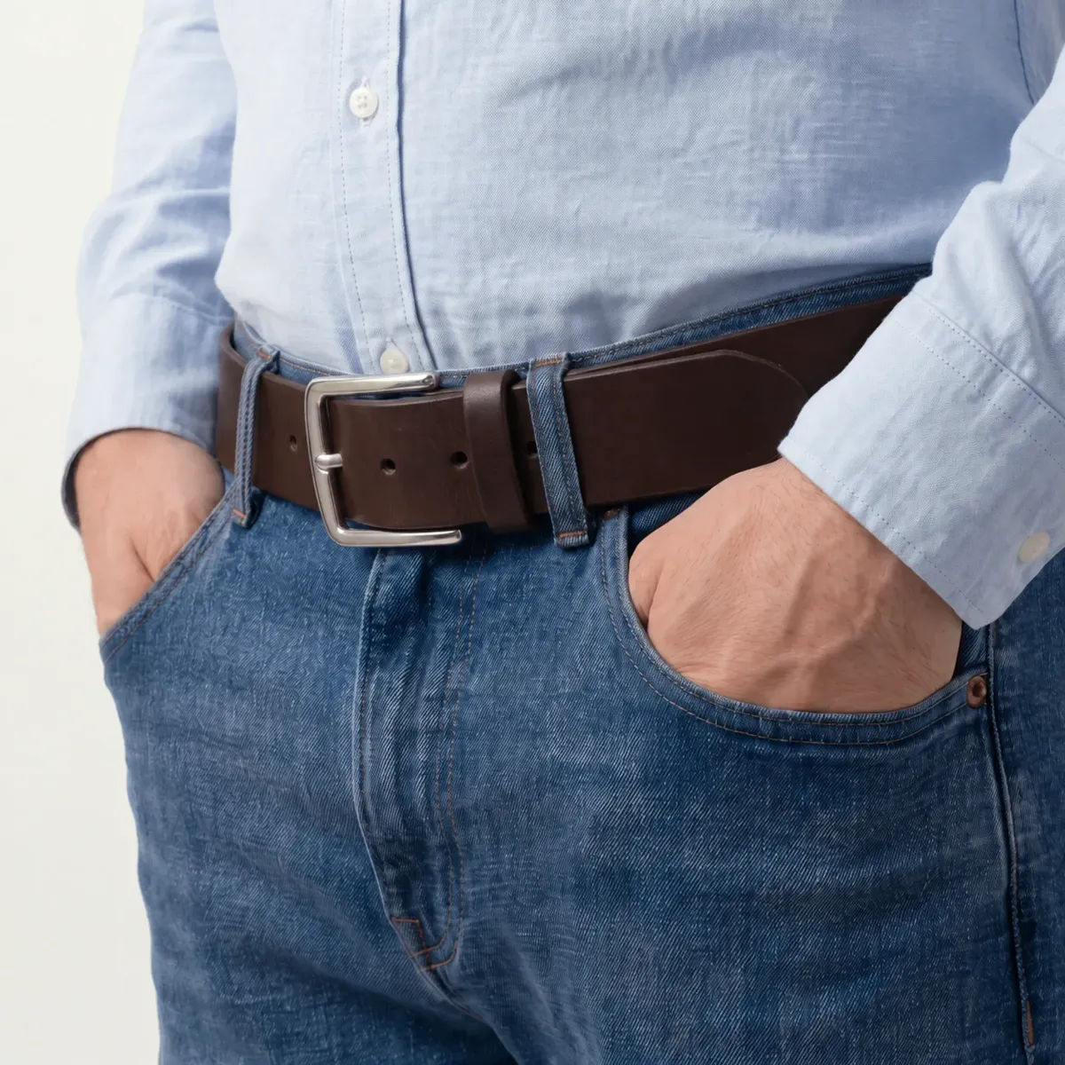 Et bredt mørkebrunt skinnbelte brukt med blå jeans